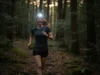Best Hiking Headlamp? A Guide to Trail Safety & Performance A confident female hiker with red hair smiles as her bright headlamp illuminates a dark forest trail at dusk.