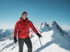 Ice Axe Skills for Hikers: Balance, Safety & Self-Arrest A male hiker in winter gear uses an ice axe for balance on a spectacular, snowy mountain ridge.