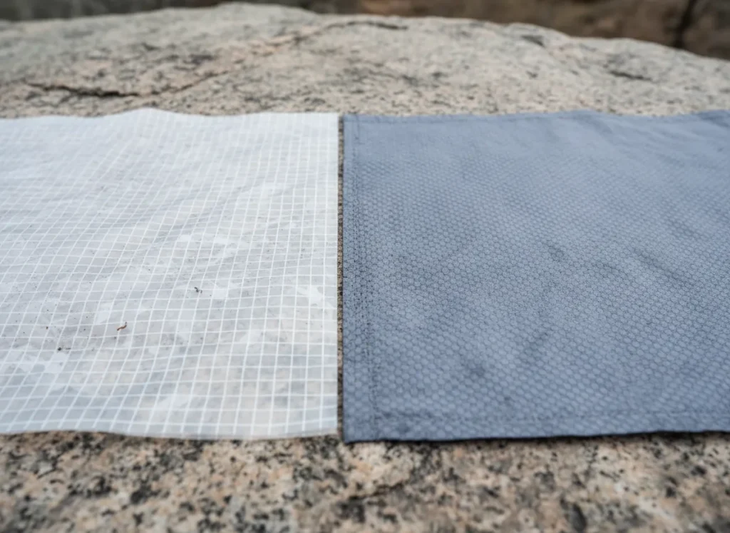 A close-up, side-by-side comparison of Dyneema Composite Fabric's grid laminate and Silnylon's woven texture.