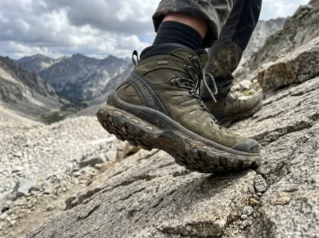 what-is-a-boot-shank-hero Close-up of hiker's boot sole pressing into rocky trail showing boot construction layers and shank support