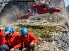 What Is Heli Hiking? Logistics, Gear & Skill Essentials Bell 212 helicopter taking off from a mountain ridge with hikers in Arc'teryx gear crouching in the foreground.