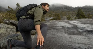 Approach Shoes vs Hiking Shoes Which Wins Where Hiker in approach shoes stepping onto a wet granite slab where the dirt trail ends