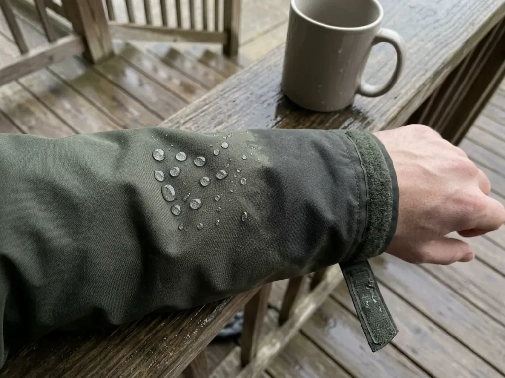 Water beading on one sleeve of a rain jacket and soaking into the other