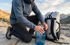 Backcountry Food Safety: The Complete Field Protocol Hiker securing a BearVault BV500 canister next to a Hyperlite Mountain Gear backpack in the Sierra Nevada.
