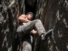 Four Way Stretch Fabric: Mobility vs. Durability A climber stemming a granite chimney, showing hiking pants stretching across the knee during a high step.