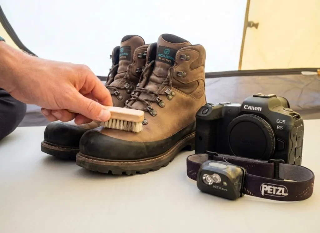 Maintaining ash-covered Scarpa boots and a taped-up Canon camera after a volcano hike.
