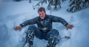 Post Holing Reality Check: Safety, Gear & Etiquette A exhausted winter hiker trapped thigh-deep in snow, struggling to climb out of a posthole in a dense forest.