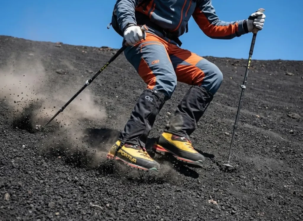 Close up of La Sportiva boots and Outdoor Research gaiters scree skiing down loose volcanic ash.
