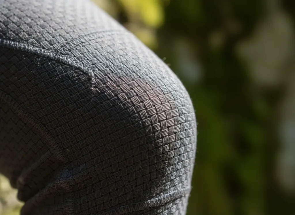 A detailed close-up of 4-way stretch fabric pulled taut, revealing its complex woven structure in natural light.