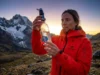 The 0.1 Micron Myth: Filter Pore Size & Virus Protection Professional hiker in a red Arc'teryx jacket inspecting a Sawyer Squeeze water filter against a mountain backdrop during golden hour.