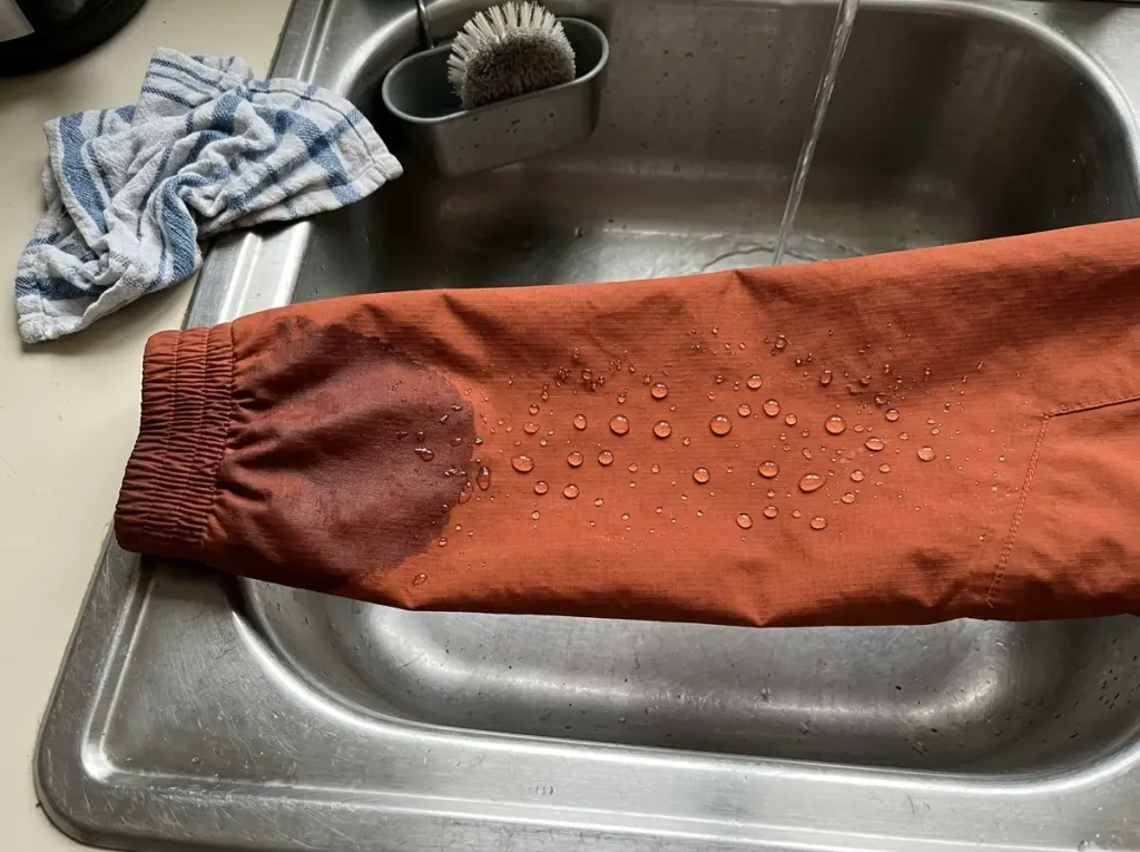 Water sprinkled on a rain jacket cuff during the bead test to check DWR