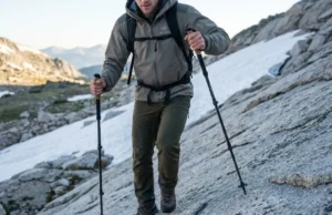 Rewire Trail Balance: Proprioception & Trekking Poles Low angle shot of a hiker descending granite, planting a carbon fiber trekking pole with precision, wearing premium Arc'teryx gear under alpine sunlight.