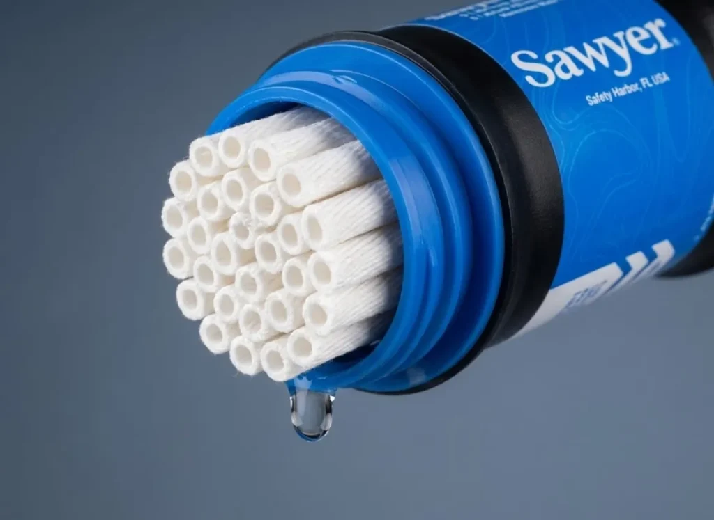 Extreme macro close-up of the hollow fiber membrane inside a Sawyer Squeeze water filter with a single water droplet.