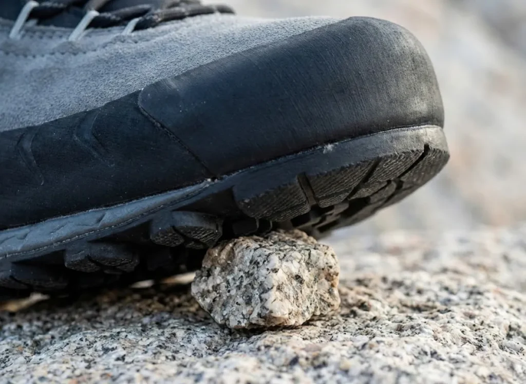 Extreme close-up of a La Sportiva approach shoe edging on rock, showing the compression of Vibram rubber.