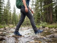 Hiking Shoes Drainage Holes: What Works & What Doesn’t Hiker crossing stream in Astral Brewer drainage shoes with water actively draining from ports