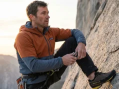 Dry Wet Footwear Overnight Without Melting Glue A professional alpinist inside a warm cabin inspecting a wet La Sportiva mountaineering boot, illuminated by warm firelight and cool window light.