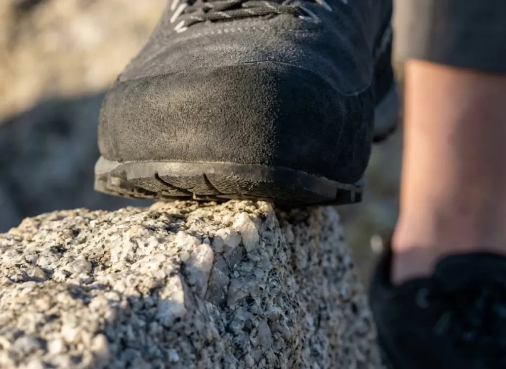 Macro photography of the toe of a La Sportiva TX4 approach shoe edging on granite, highlighting the sticky rubber texture.