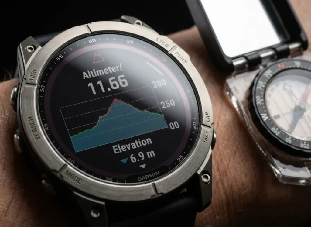 Macro close-up of a Garmin Fenix watch displaying altimeter data next to a Suunto sighting compass, highlighting precision navigation tools.