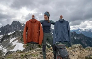 Hardshell vs Softshell: The Layering Decision Most Hikers Blow Hiker comparing hardshell and softshell jackets at alpine ridge pass with mountain views