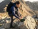 Downhill Heel Slippage? The Lacing Fix That Actually Works Hiker adjusting hiking boot laces on steep mountain descent to prevent heel slippage