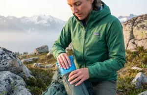 Pack It In Pack It Out Waste Management: The Field Guide Hiker packing out human waste in WAG bag at alpine terrain following Leave No Trace principles
