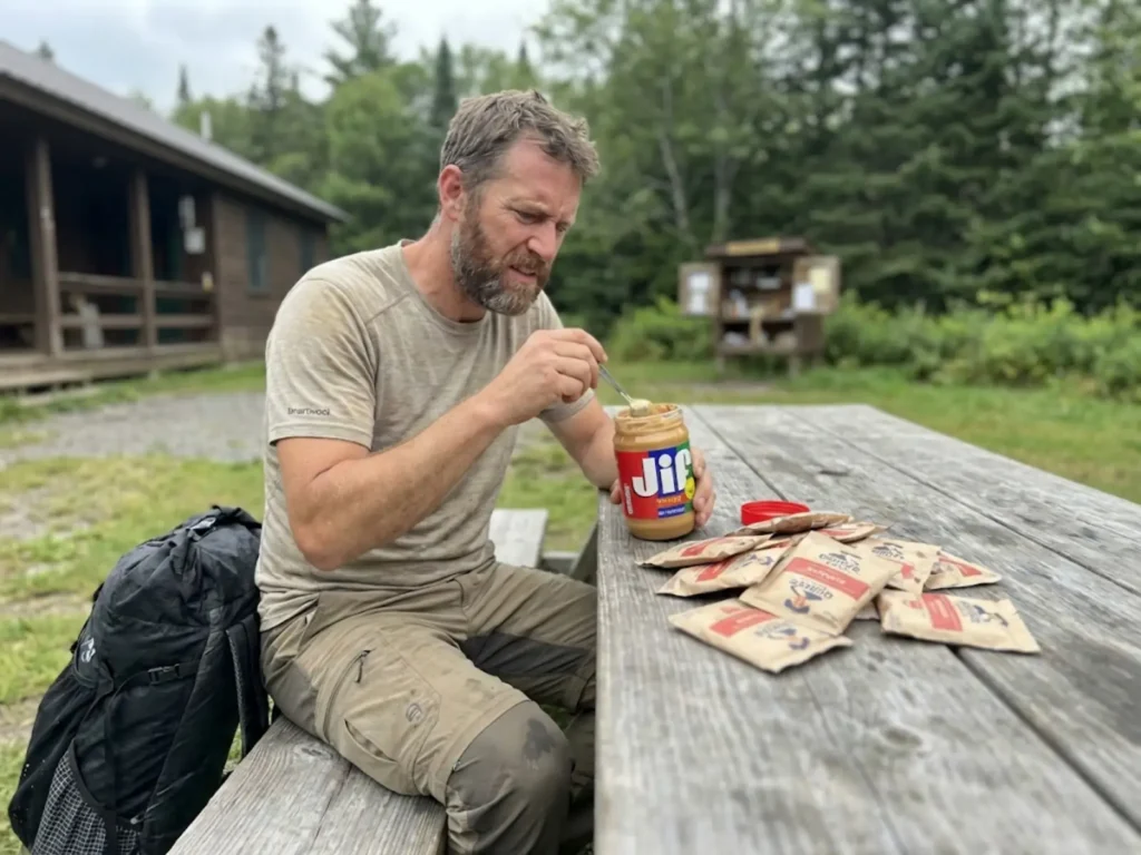 Hiker experiencing palate fatigue rejecting oatmeal packets while eating peanut butter due to hiker hunger