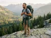 Is Your Sternum Strap Height Too High or Too Low? Hiker adjusting sternum strap height on an Osprey pack on a granite ledge at dawn
