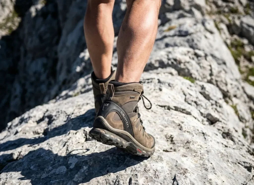 Close-up of Salomon hiking boots stepping firmly on a rocky ridge, demonstrating efficient movement and stability on uneven terrain.