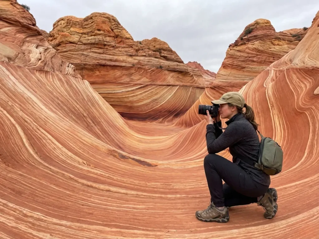 Photographer capturing the iconic sandstone patterns at The Wave Coyote Buttes permitted hiking area