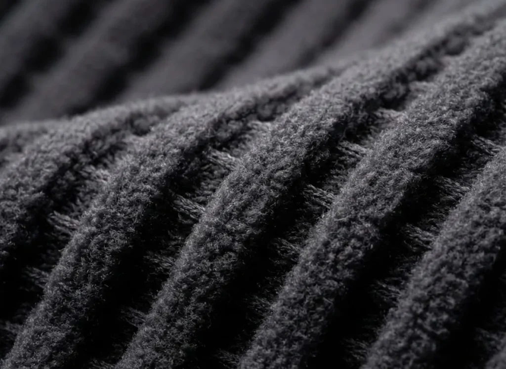 Extreme macro close-up of Polartec Power Grid fabric showing the raised pillars and deep air channels designed for moisture management.