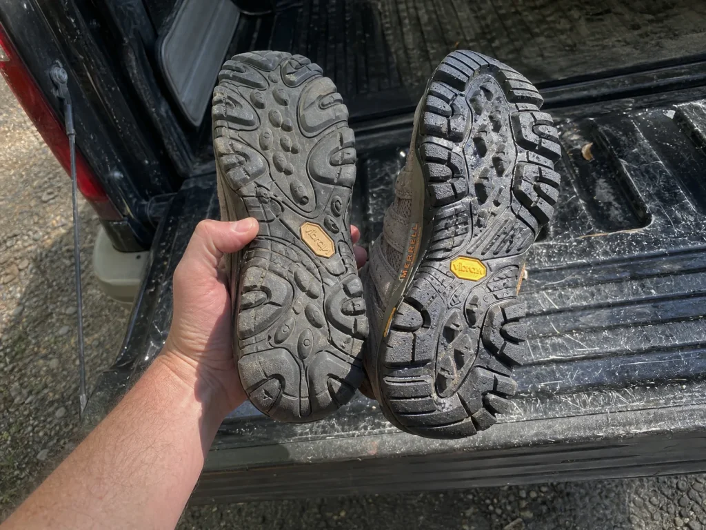 Two hiking shoe outsoles held side by side showing different rubber compounds under the same brand