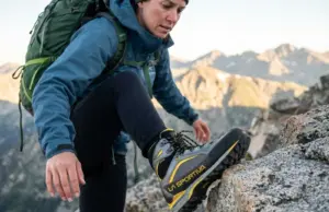 Choosing Hiking Boot Stiffness That Matches the Terrain Hiker testing boot stiffness on rocky alpine terrain using La Sportiva hiking boots