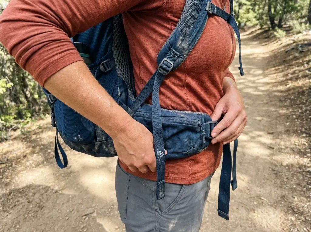 Hip belt of a loaded Gregory pack riding correctly on a hiker's hips to show fit over volume