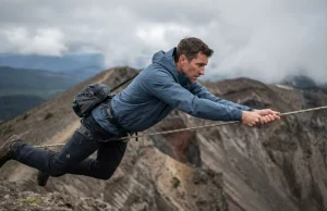 Stop White-Knuckling Fixed Ropes on the Ridge Hiker using fixed rope hand over hand technique on alpine ridge, horizontal body position with pack towed behind