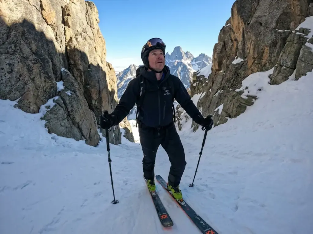 Ski mountaineer ascending Grand Teton couloir in morning light with avalanche timing awareness 