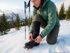The Boot-Crampon Pairing Mistake Every Hiker Makes Hiker attaching Petzl crampon to Scarpa hiking boot on snowy Rocky Mountain slope