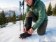 The Boot-Crampon Pairing Mistake Every Hiker Makes Hiker attaching Petzl crampon to Scarpa hiking boot on snowy Rocky Mountain slope