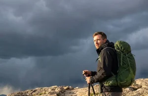 Lightning Hit the Ridge and You Froze. Read This Hiker on exposed alpine ridge watches storm move in, hand releasing trekking poles—lightning safety hiking open terrain
