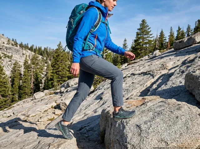 petite-hiking-pants-women-alpine-trail-hero Petite woman hiker in Outdoor Research Ferrosi pants stepping over granite boulder on alpine trail