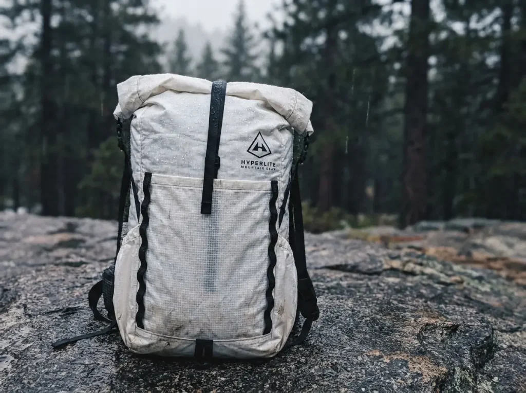 White Dyneema HMG Southwest roll-top pack beading rain with no main zipper visible