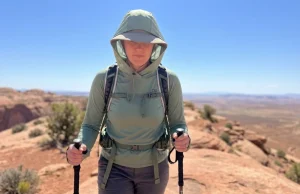 Why Smart Hikers Wear Sun Hoodies in Brutal Heat Hiker wearing a sun hoodie with hood up crosses an exposed desert ridge in brutal heat