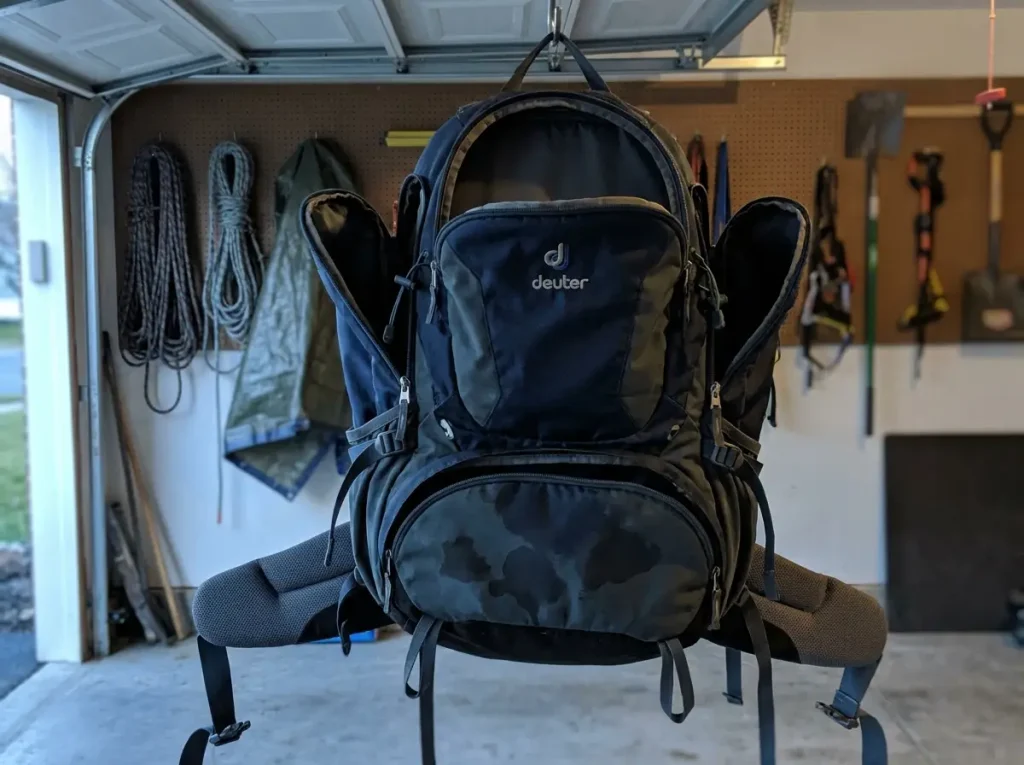 A backpack hung upside down with pockets open to dry out and prevent mold after a wet hike
