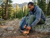 The 80-Hour Rule for Breaking In Hiking Boots Hiker tightening full-grain leather Asolo boots at sunrise trailhead — hiking footwear break in timeline
