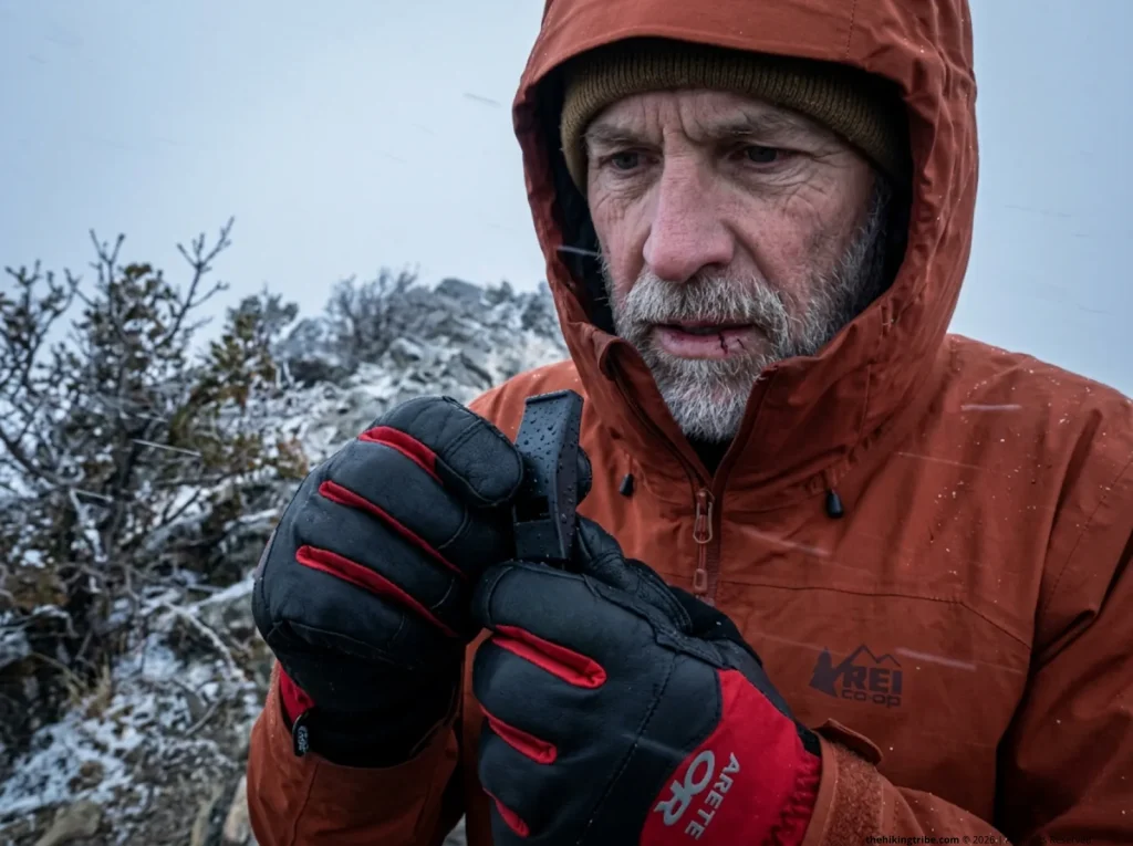 Search and rescue worker inspecting a pealess survival whistle in freezing sleet