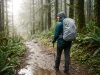 Why a Rain Cover Won’t Waterproof Your Backpack Hiker with a rain-covered backpack on a wet trail, showing why you still need to waterproof your backpack