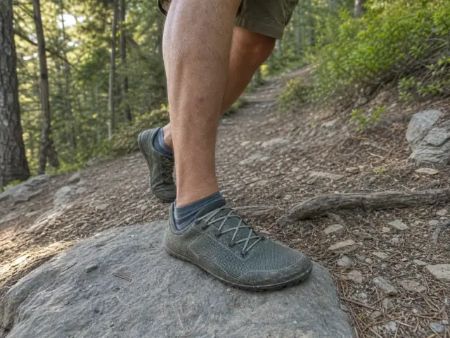 0-minimalist-hiking-shoes-transition-guide-hero Hiker in minimalist zero-drop trail shoes stepping onto a rocky trail