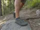 How to Switch to Minimalist Hiking Shoes on Trail Hiker in minimalist zero-drop trail shoes stepping onto a rocky trail