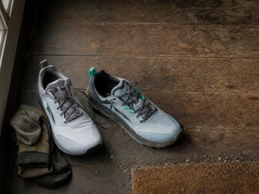 Two pairs of low-cut hiking shoes side by side, one waterproof and one mesh, for seasonal rotation