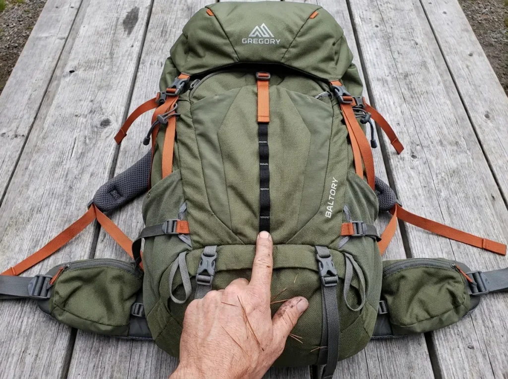 Empty Gregory backpack laid flat showing compression straps, daisy chains, and lash tabs