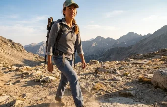 7 Best Hiking Shoes for Wide Feet Women 2026 Woman with wide feet hiking on rocky trail in supportive low hiking shoes during golden hour